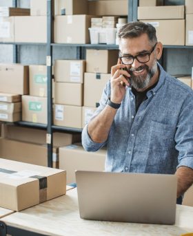 Mature men at online shop. He is owner of small online shop. Receiving orders and packing boxes for delivery.